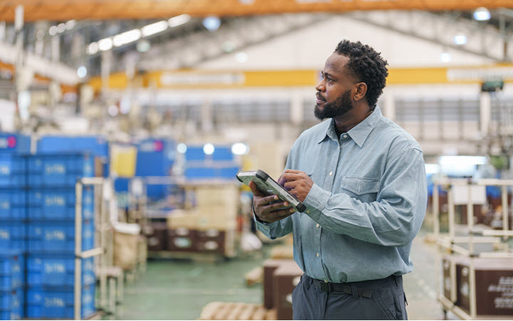 A man using a tablet computer in a warehouse.